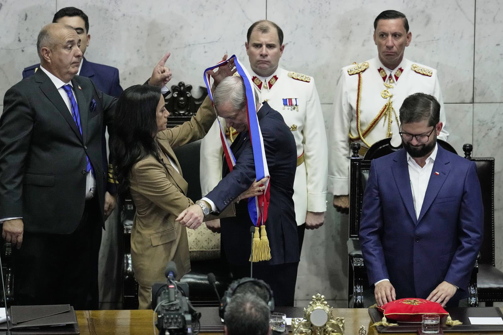 Predsedníčka Senátu Paulina Nunezová (vľavo) vkladá prezidentskú šerpu nastupujúcemu prezidentovi Josému Antoniovi Kastovi počas jeho inaugurácie vo Valparaiso.