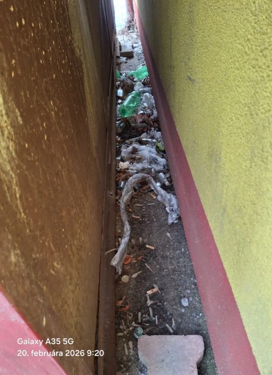 Znečistený vonkajší priestor medzi budovou predajne a skladom