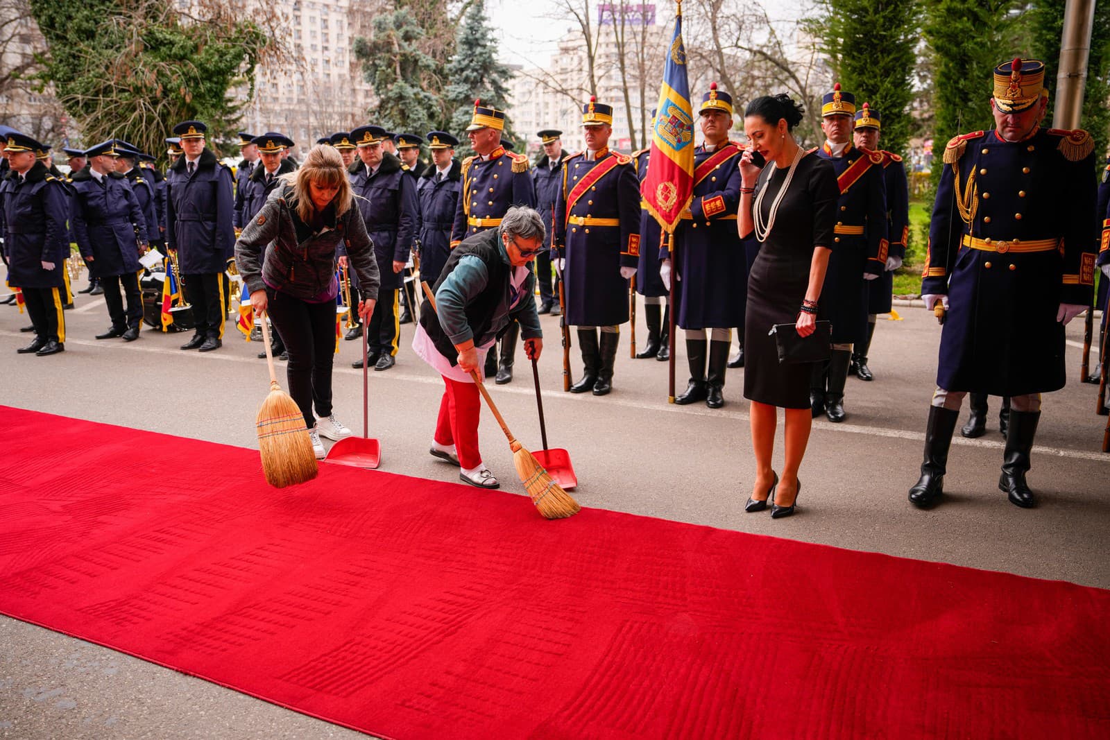  Bukurešť - Ženy zametajú červený koberec pred príchodom slovenského premiéra Roberta Fica v Bukurešti v piatok 27. marca 2026.