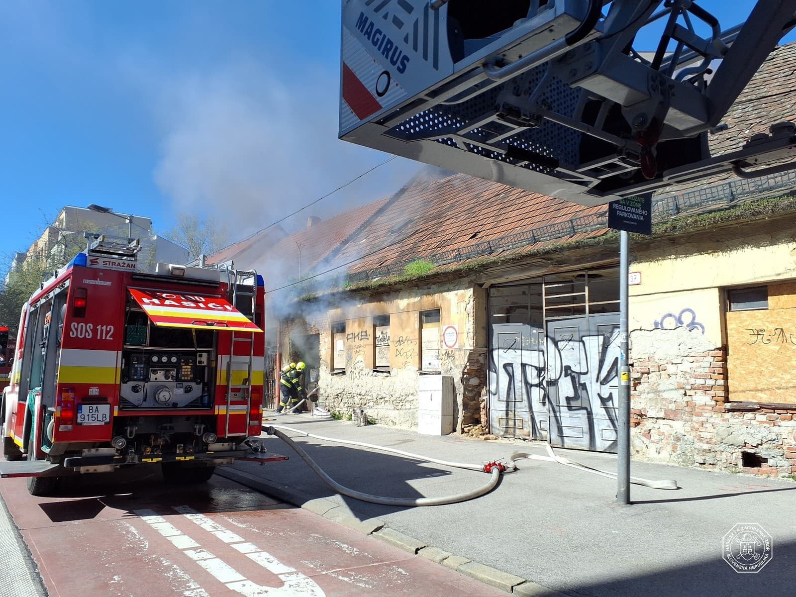 Hasiči zasahujú pri požiari na streche opustenej budovy v Bratislave.