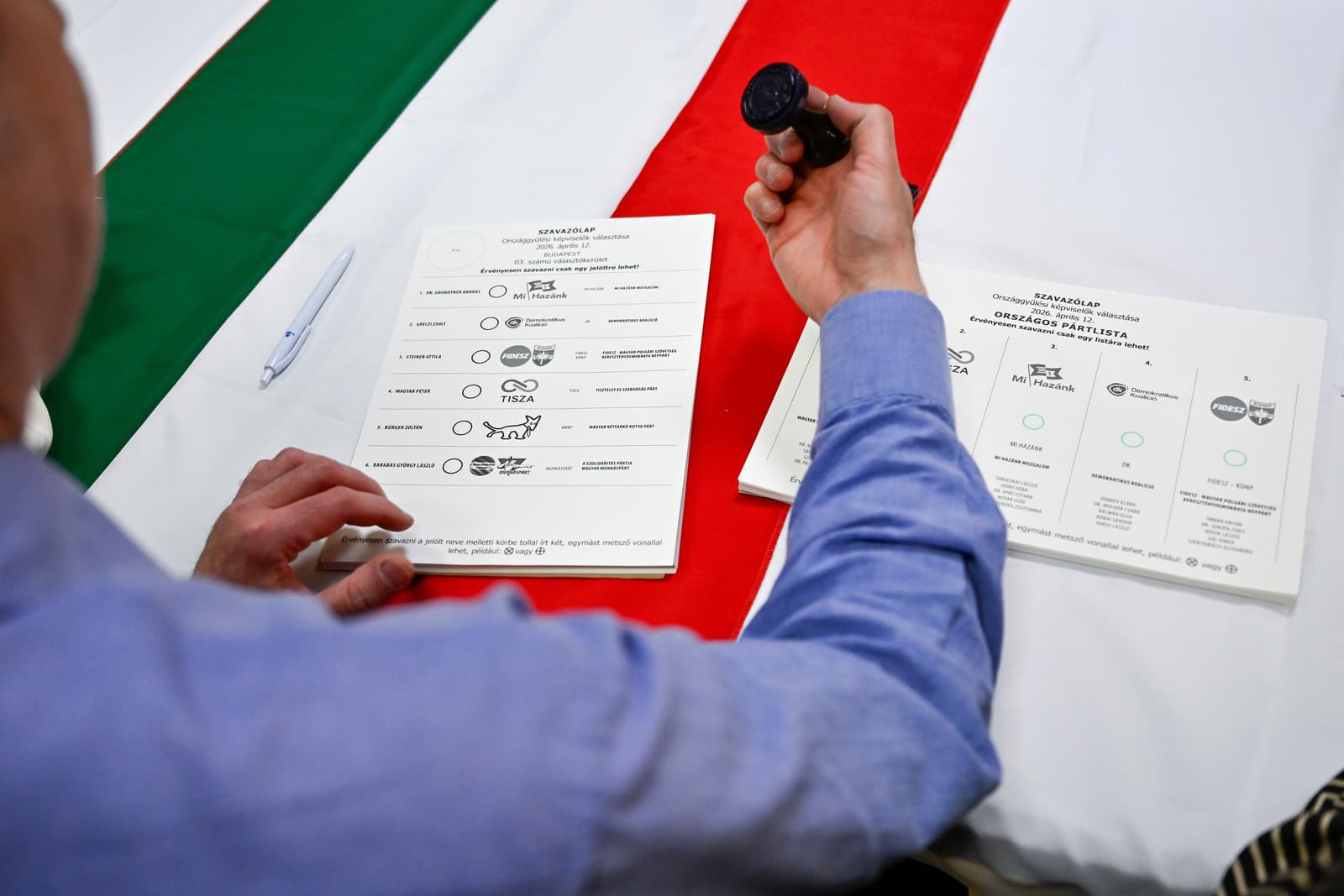 Pracovník volebnej komisie pripravuje hlasovací lístok počas hlasovania v parlamentých voľbách vo volebnej miestnosti v Budapešti