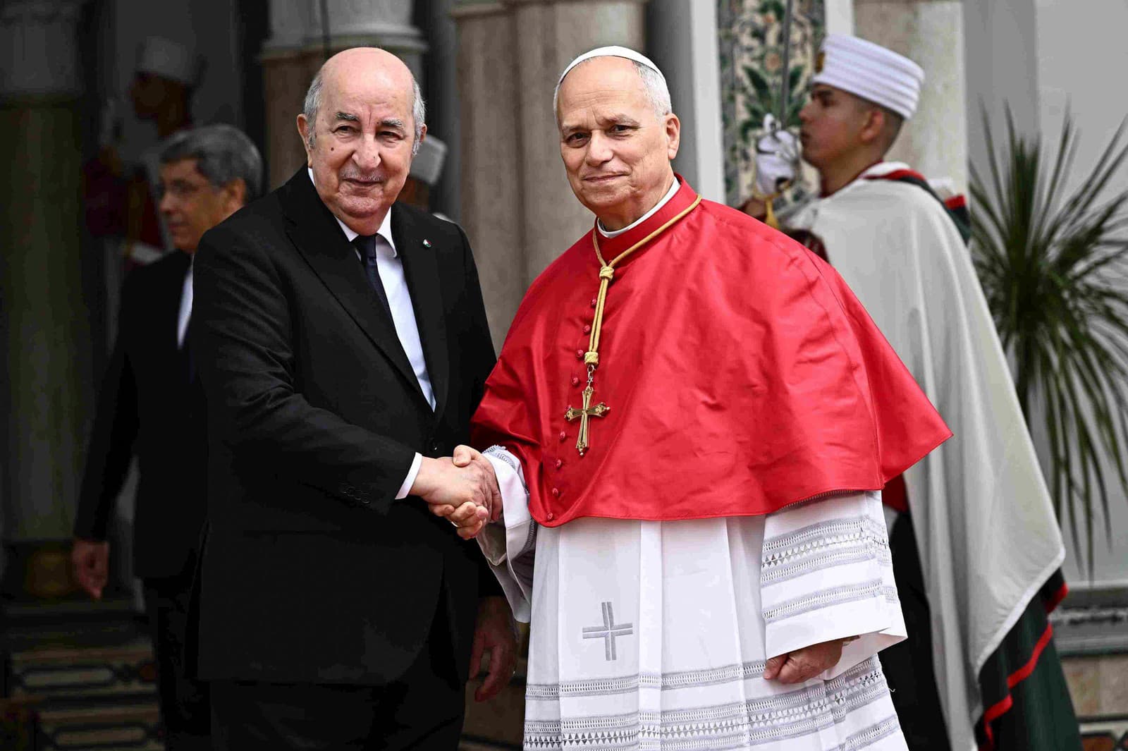 Pápež Lev XIV. (vpravo) si podáva ruku s alžírskym prezidentom Abdalom Madžídom Tabbúnom pred ich stretnutím v prezidentskom paláci El Mouradia v Alžíri