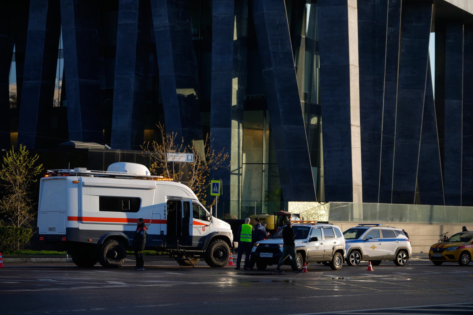 Vozidlá špeciálnych zložiek parkujú pri poškodenom bytovom dome na ulici Mosfilmovskaja po útoku ukrajinského dronu v Moskve.