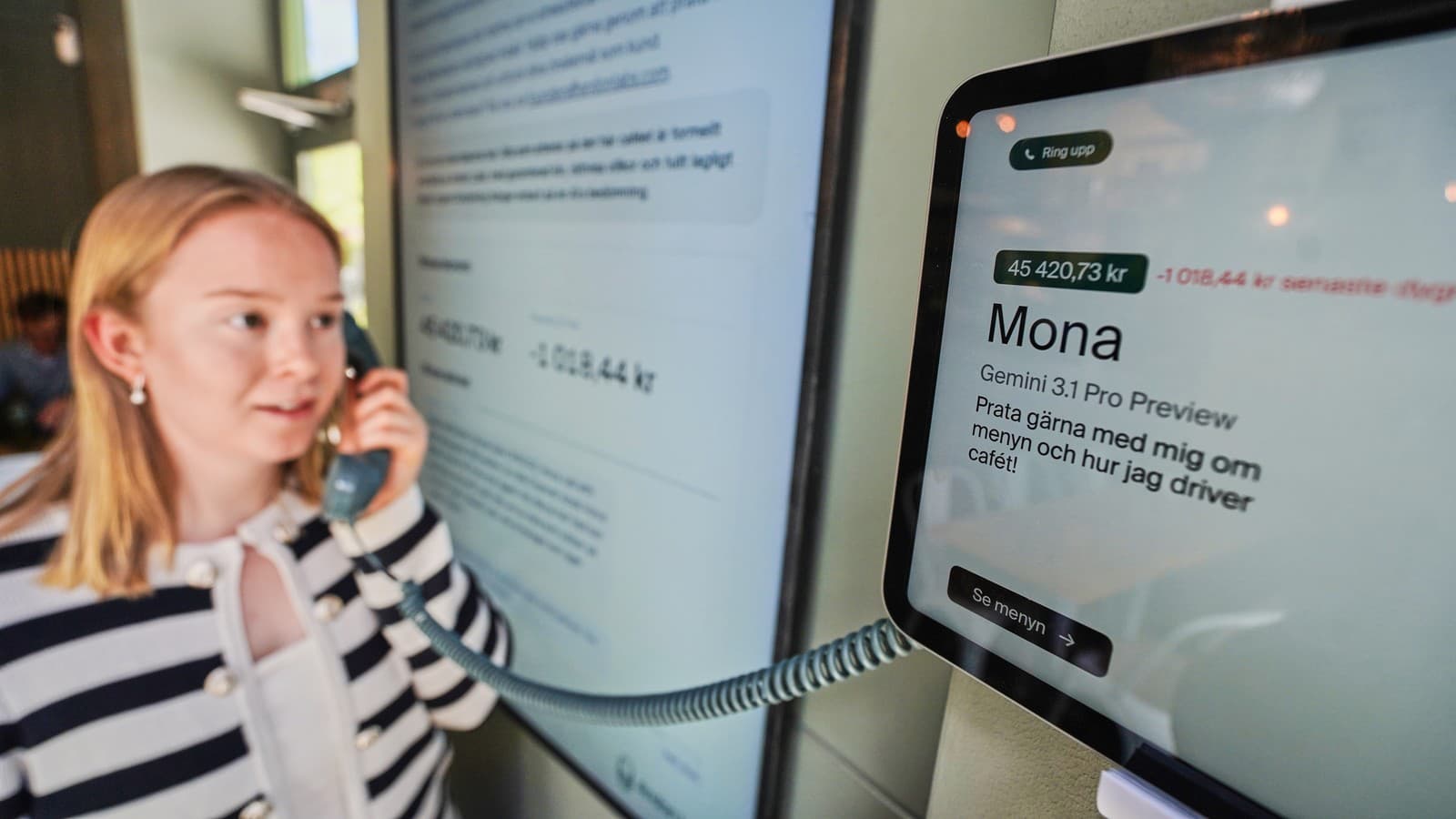 Hanna Peterssonová, členka technického tímu spoločnosti Andon Labs, používa telefónnu slúchadlu na komunikáciu s umelou inteligenciou „Mona“ v kaviarni Andon Café.