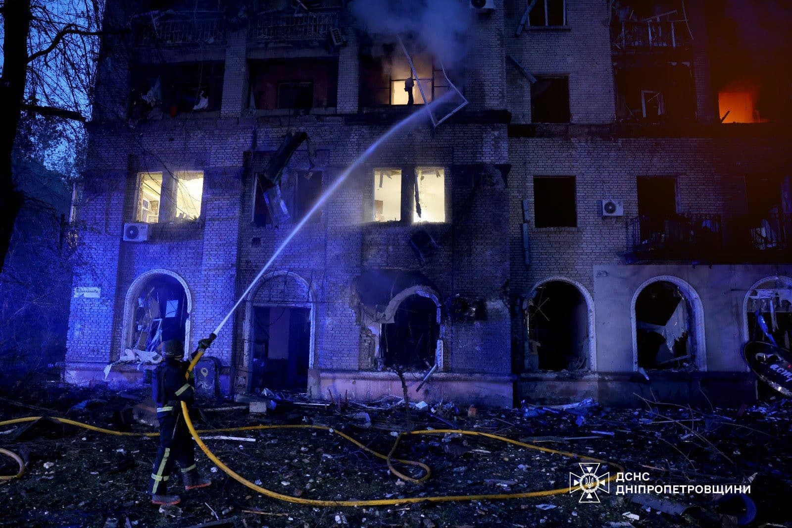 Hasič hasí požiar zničeného obytného domu po ruskom raketovom útoku v meste Dnipro.