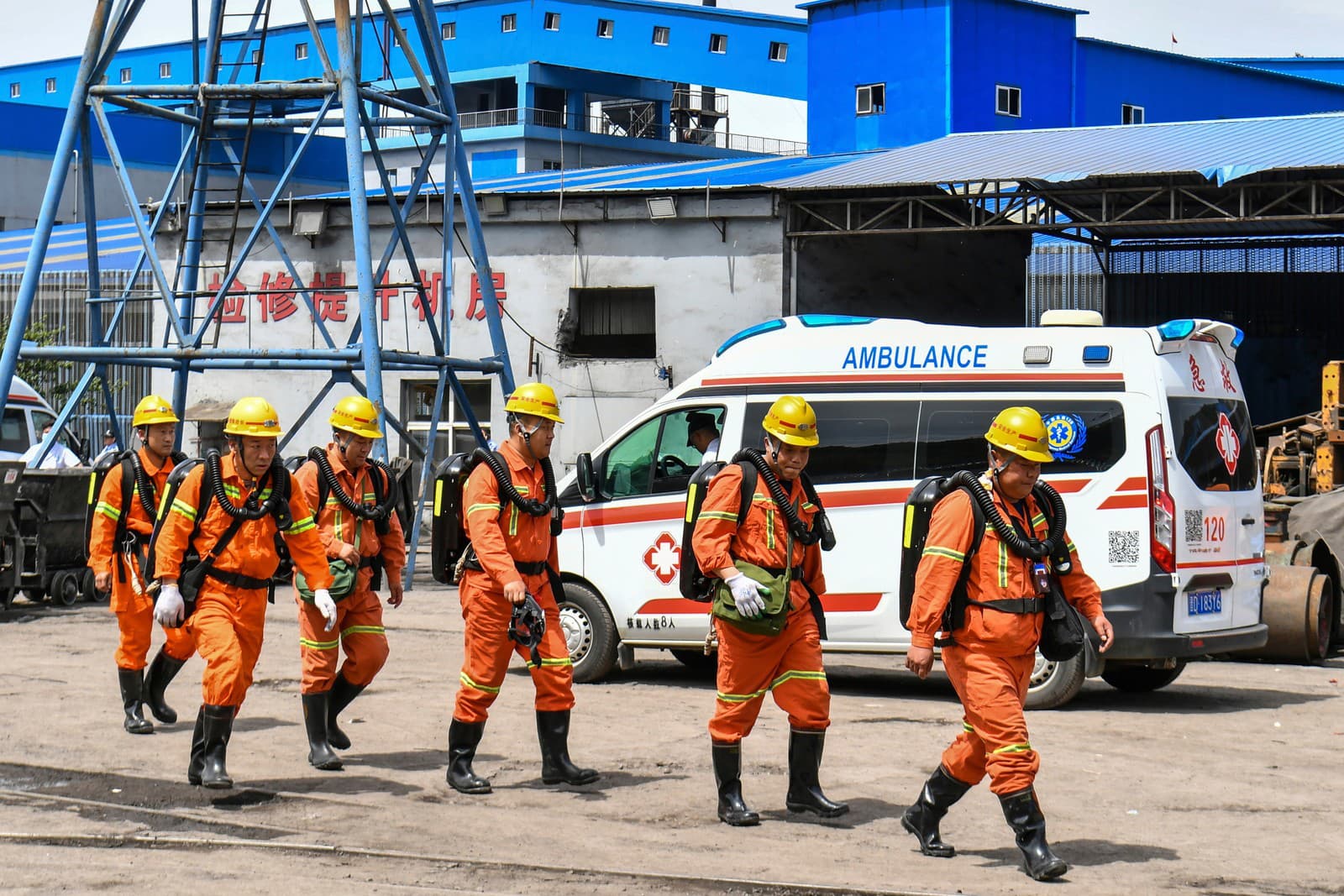 Na tejto fotografii, ktorú zverejnila tlačová agentúra Xinhua, záchranári prechádzajú okolo sanitky po výbuchu v uhoľnej bani Liushenyu v meste Changzhi v okrese Qinyuan v severočínskej provincii Shanxi.
