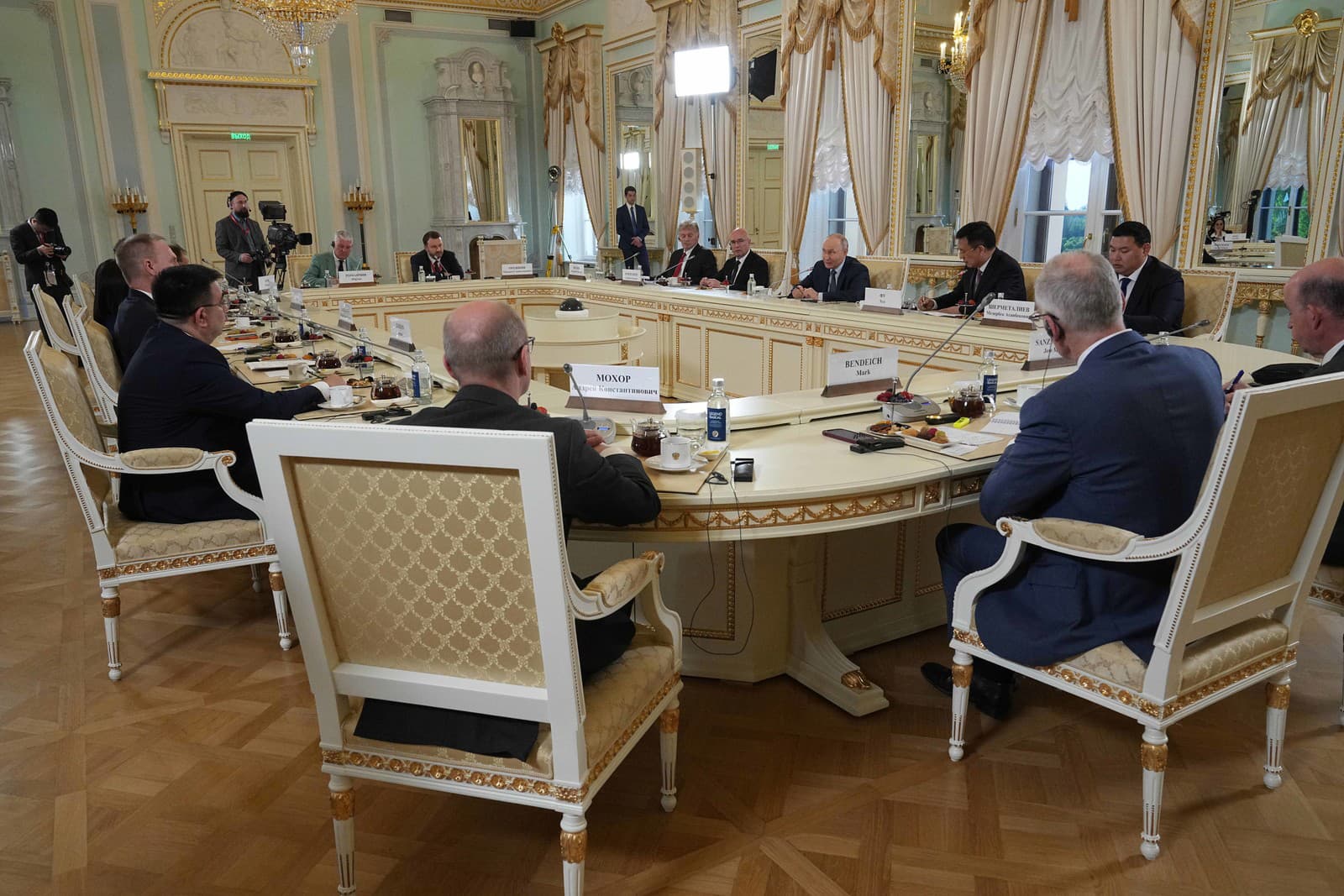 Ruský prezident Vladimir Putin (v pozadí piaty sprava) počas stretnutia so zástupcami medzinárodných tlačových agentúr v rámci Petrohradského medzinárodného ekonomického fóra (SPIEF) v Petrohrade.