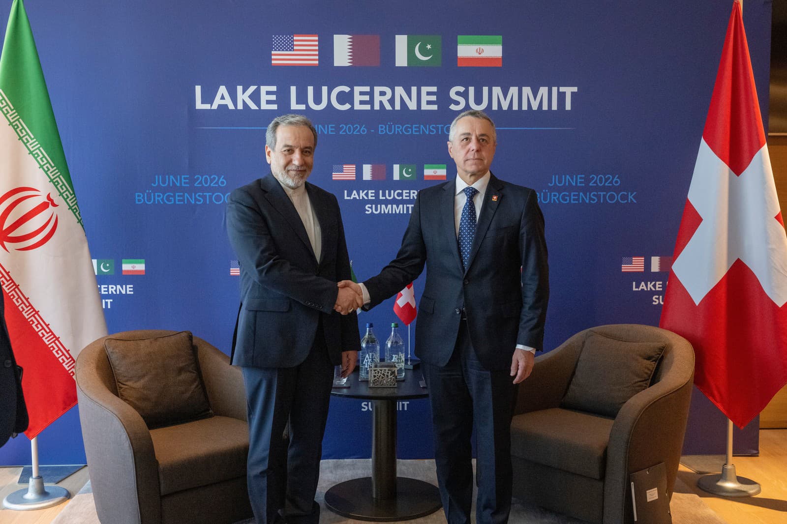Iránsky minister zahraničných vecí Abbás Arákčí (vľavo) si podáva ruku so svojím švajčiarskym rezortným partnerom Ignaziom Cassisom počas ich bilaterálneho stretnutia pred prvým kolom rokovaní USA s Iránom