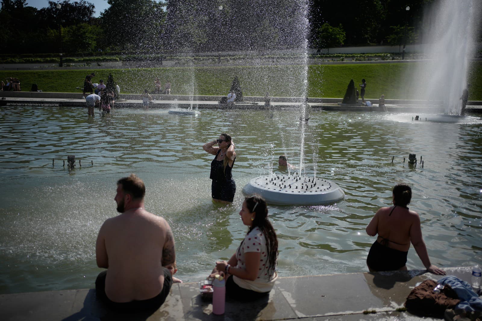 Ľudia v Paríži sa chladia vo fontáne.