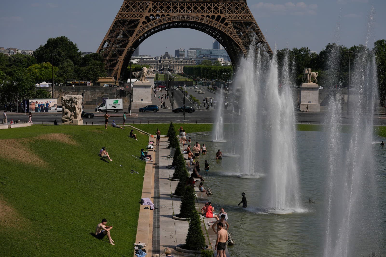 Ľudia sa osviežujú vo fontáne Trocadero pri Eiffelovej veži počas vlny horúčav v Paríži.