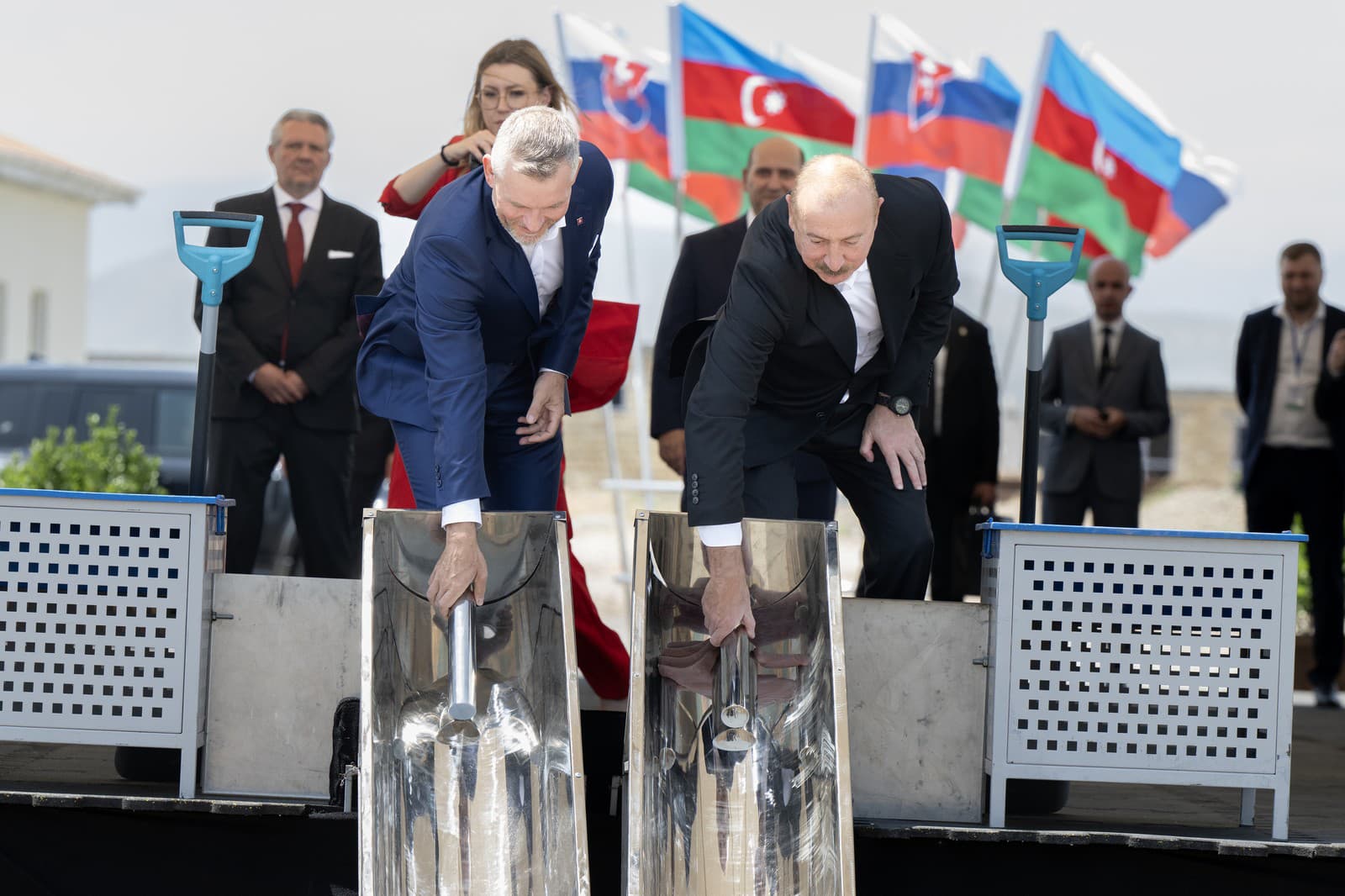 Prezident Azerbajdžanu Ilhan Alijev (vpravo) a prezident SR Peter Pellegrini (vľavo) vkladajú do betónového základu stavby budúcej školy Milana Rastislava Štefánika symbolické schránky v regióne Agdan