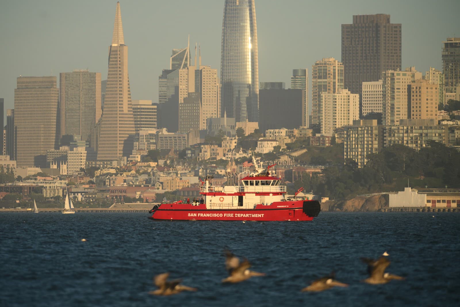 Plavidlo hasičského zboru v San Franciscu prechádza popri panoráme mesta a hľadá nezvestné obete po nehode lode neďaleko ostrova Alcatraz pri San Franciscu