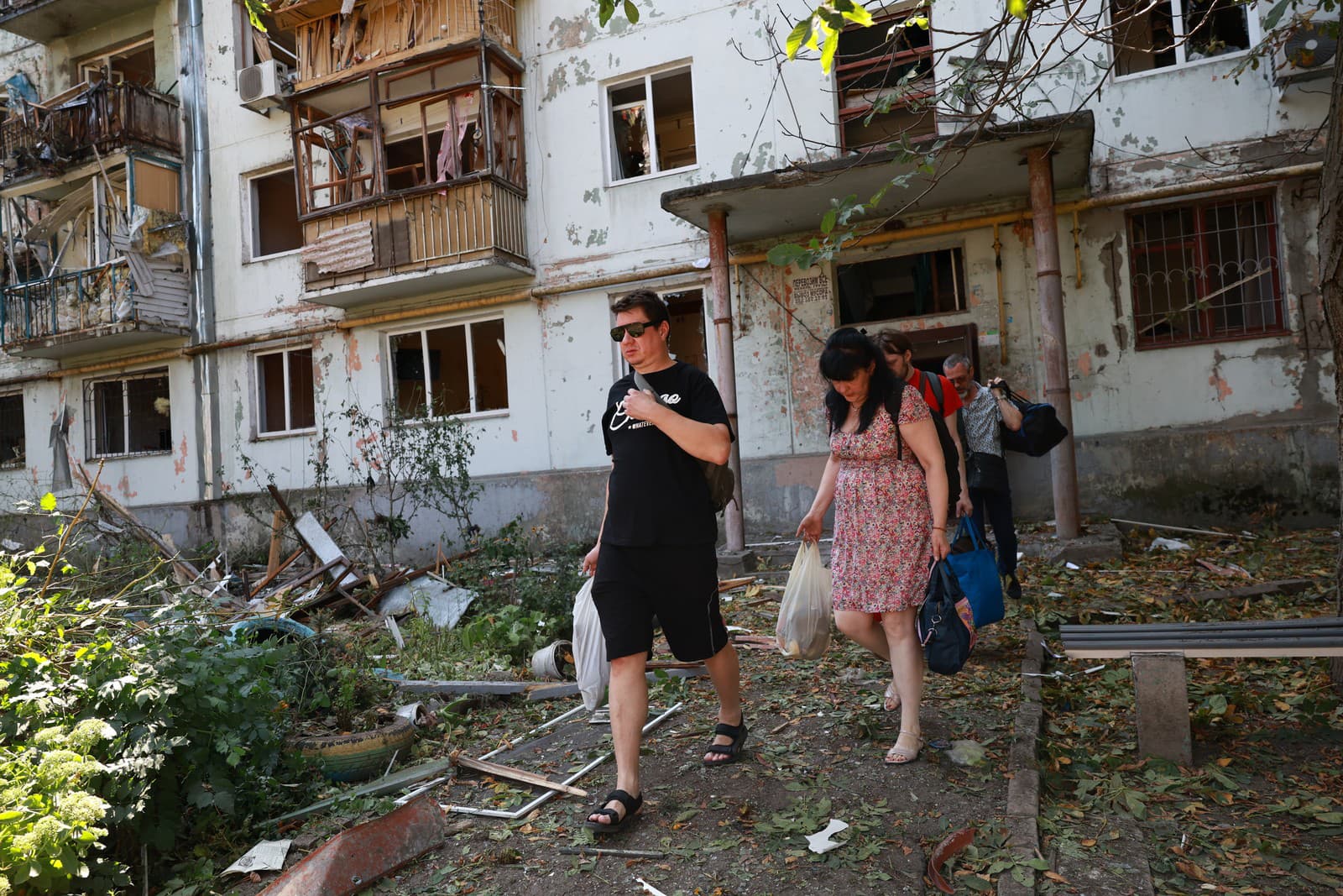 Obyvatelia opúšťajú svoje poškodené domy po útoku ruskej leteckej navádzanej bomby v Záporoží