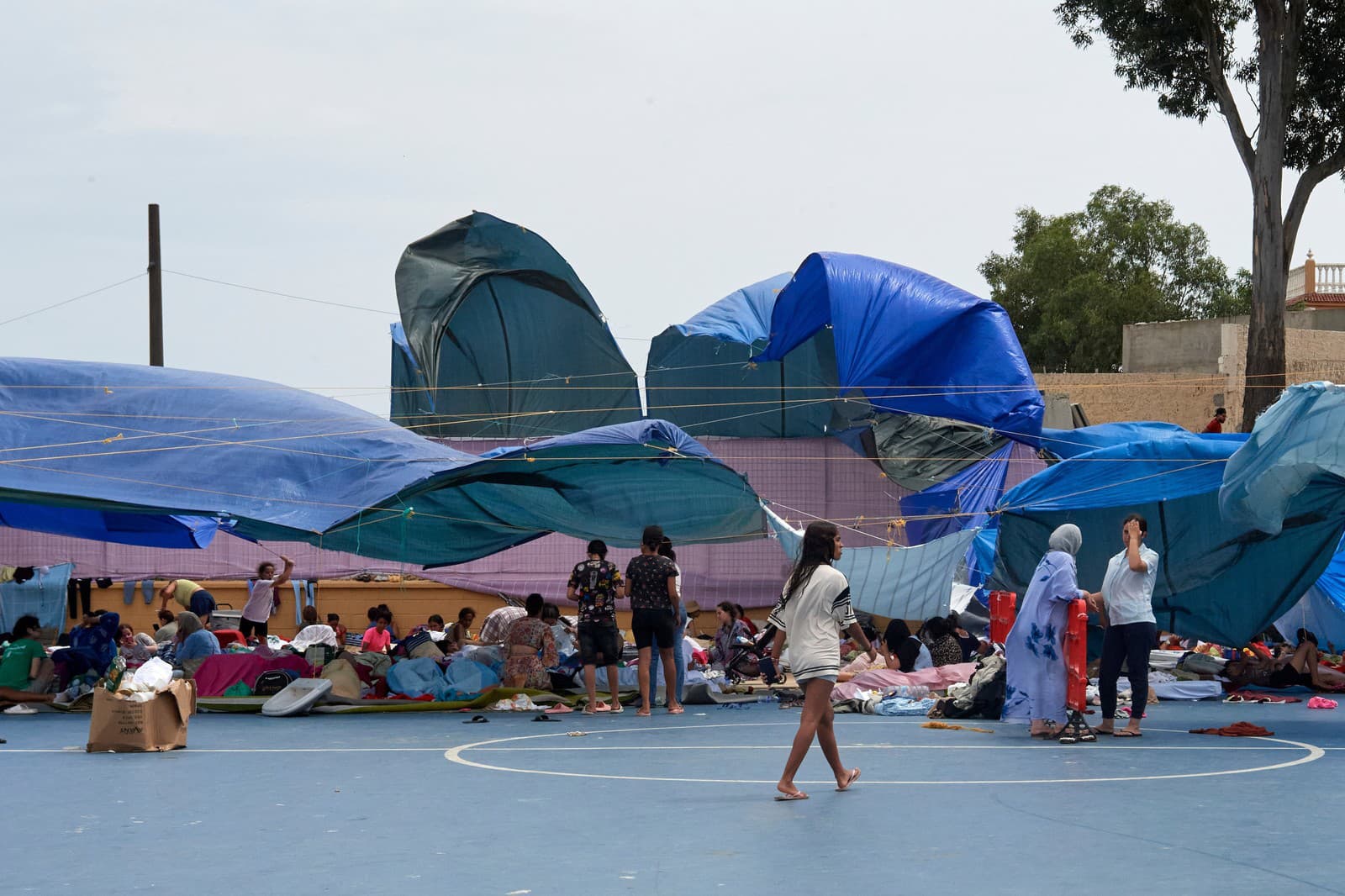 Migranti, ktorí prekročili hranicu z Maroka do Španielska sa zhromažďujú v športovom centre v španielskej exkláve Ceuta