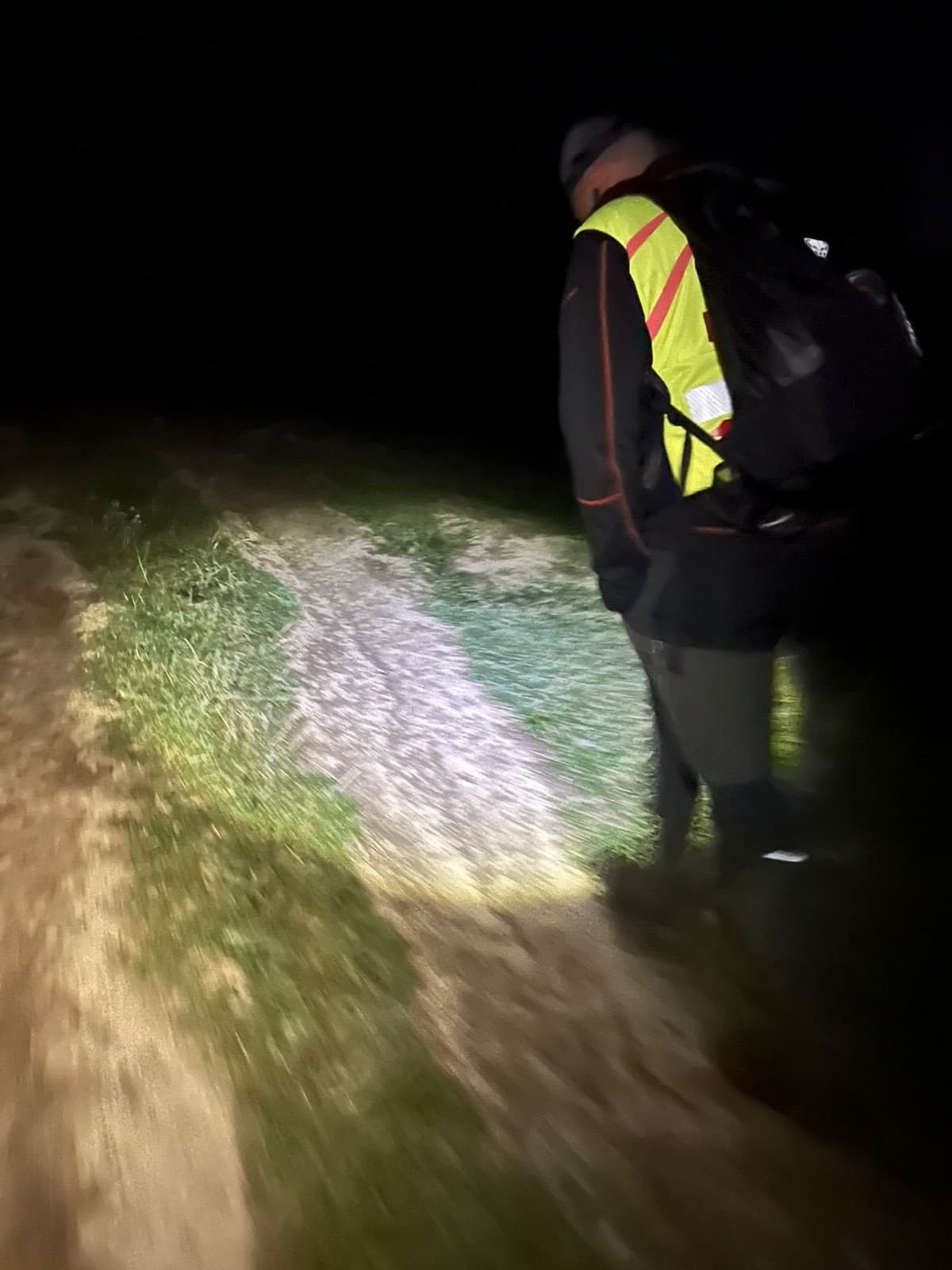 Záchranár HZS pri svetle čelovky kráča turistickým chodníkom
