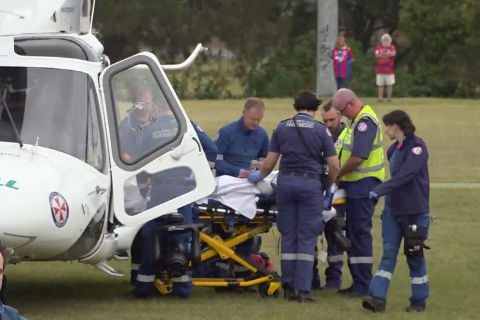 Na videosnímke záchranári nakladajú zranenú osobu do helikoptéry po tom, čo auto vrazilo do davu fanúšikov ragby v austrálskom meste Newcastle.