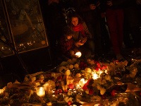 Svičky a kvetky pred kaviarňou, v ktorej zahynulo 19 ľudí.