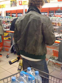 Vlado Voštinár pri pokladni s fľašami alkoholu v ruke.