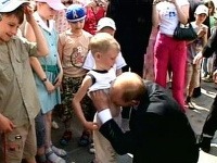 Putin bozkáva brucho malého chlapca.