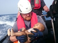 Člen posádky humanitárnej organizácie Sea-Watch drží na rukách utopené dieťa.
