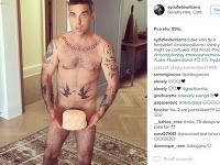 Robbie Williams sa producíroval pred svojou ženou nahý a s tortou v rozkroku. 