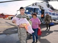 Záchranár nesie chlapčeka na rukách Záchranár nesie chlapčeka na rukách