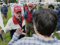 Pŕivrženec Donalda Trumpa kričí na anti-Trump protestujúceho.