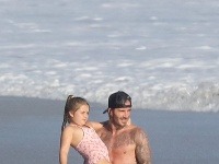 David Beckham nosí svoju dcérku na rukách. 