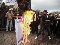 Palestínski demonštranti na protest pália izraelskú a americkú zástavu.