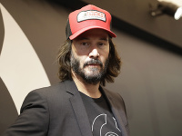 Keanu Reeves nosí bradu a dlhé vlasy.