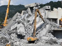 Hasiči s ťažkými mechanizmami pracujú na odstraňovaní trosiek z diaľničného mosta Morandi