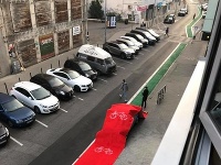 Červený koberec na vozidle, ktoré bolo zaparkované na cyklochodníku. 