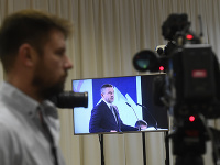 Novinár sleduje v tlačovom stredisku príhovor podpredsedu strany SMER-SD Petera Pellegriniho