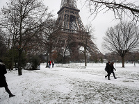 Ľudia kráčajú okolo Eiffelovej veže, ktorú pre silné sneženie zatvorili