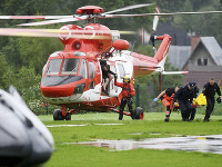 Záchranári prenášajú z helikoptéry do sanitky prvých ľudí zranených počas búrky s bleskami 22. augusta 2019 v poľskom Zakopanom.