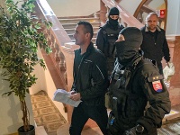 Polícia eskortuje obvinených zo skupiny tzv. takáčovcov v priestoroch Špecializovaného trestného súdu v Banskej Bystrici