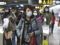 Ľudia nosia masky na stanici metra v Taipei na Taiwane.