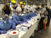 Ruskí lekárski odborníci kontrolujú pasy cestujúcim z Talianska na moskovskom letisku Šeremetievo.
