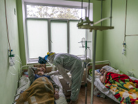Lekár v špeciálnom ochrannom odeve sa rozpráva s pacientom infikovaným novým typom koronavírusu na Ukrajine Lekár v špeciálnom ochrannom odeve sa rozpráva s pacientom infikovaným novým typom koronavírusu na Ukrajine