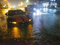 Motoristi jazdia po zatopenom bulvári Gause v meste Slidell v štáte Louisiana.