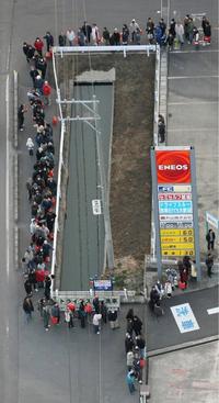 Ľudia vyčkávajú v rade pred benzínkou vo Watari.
