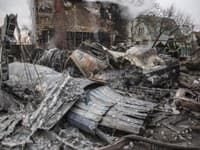 Ukrajinský hasič prechádza medzi fragmentmi zostreleného lietadla v Kyjeve