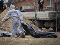 Muži v ochranných výstrojoch exhumujú telá civilistov zabitých počas ruskej okupácie v Buči
