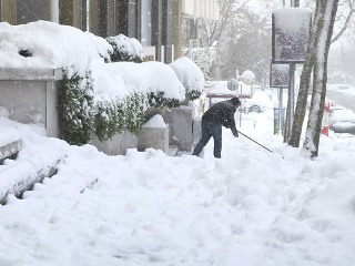 Muž odhŕňa sneh v