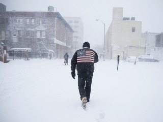 Muž kráča počas snehovej
