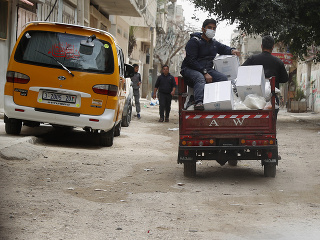 Palestínski pracovníci distribuujú potravinovú