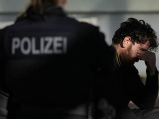 Policajtka stráži zadržaného migranta