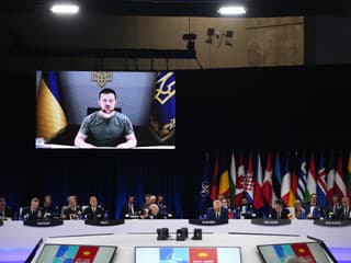 Ukrajinský prezident Volodymyr Zelenskyj (na obrazovke) sa prihovára lídrom krajín NATO na summite Severoatlantickej aliancie v Madride