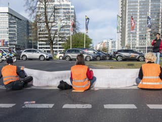 Klimatickí aktivisti blokujúci premávku
