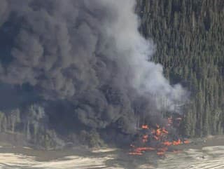 Požiar po páde lietadla Douglas C-54 Skymaster do rieky Tanana pri meste Fairbanks na Aljaške, utorok 23. apríla 2024. 